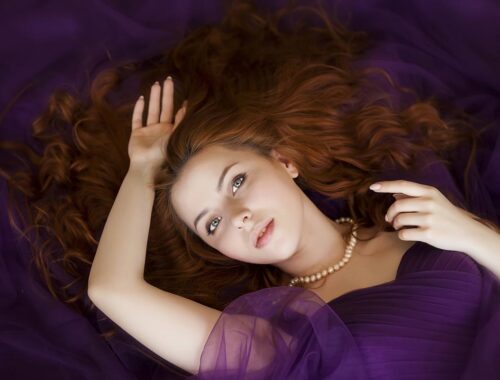 beautiful women laying down in pourple dress with brown hair