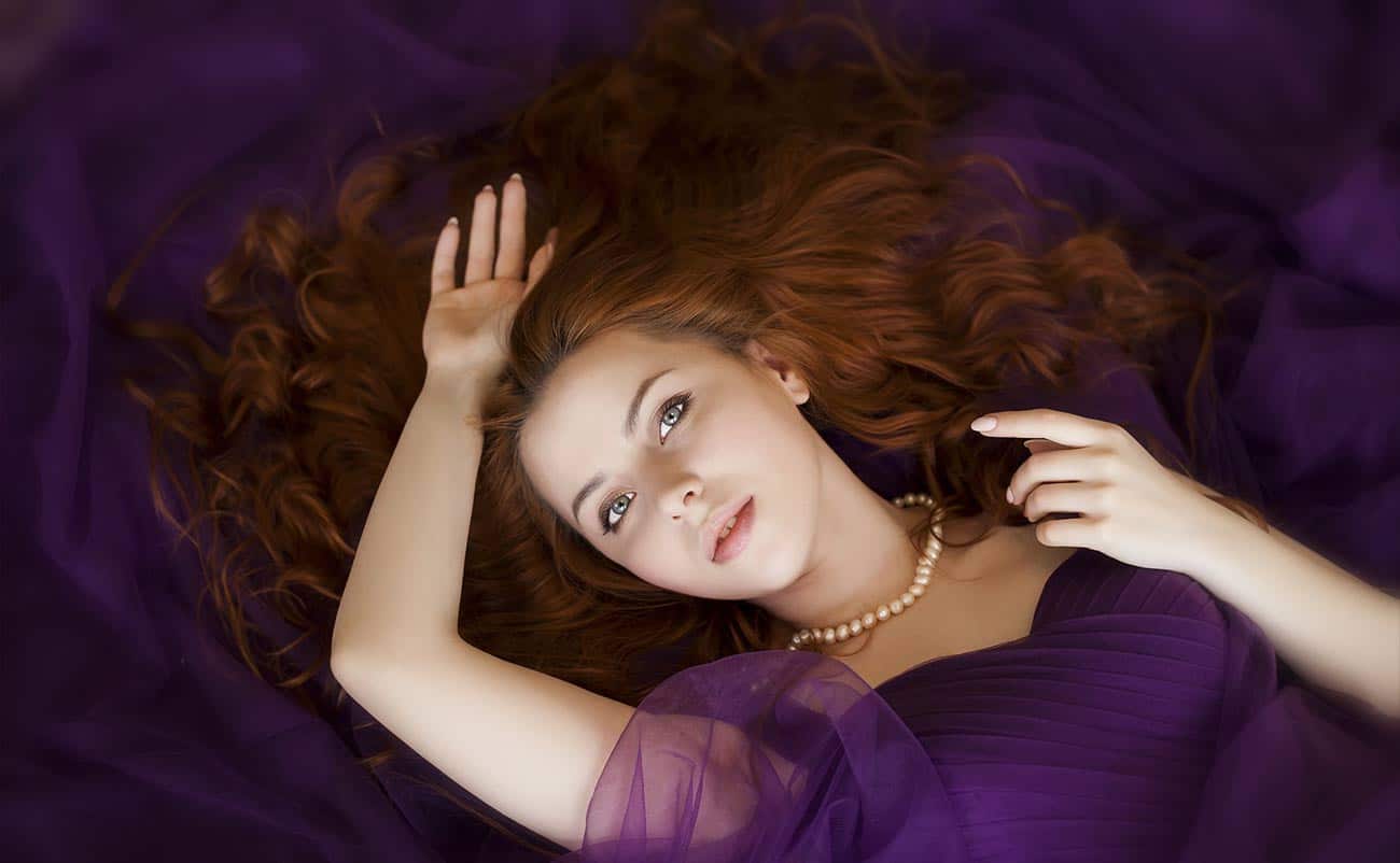 beautiful women laying down in pourple dress with brown hair