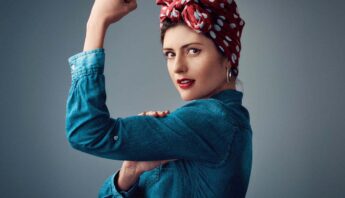 beautiful women showing her elbow for strength sign in blue shirt with red scarf