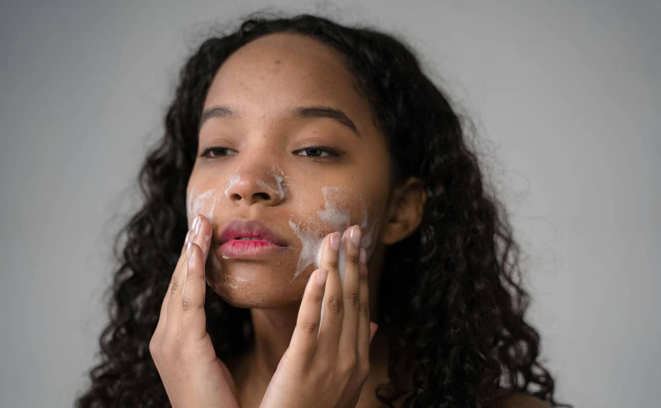 black girl doing face wash for skin care