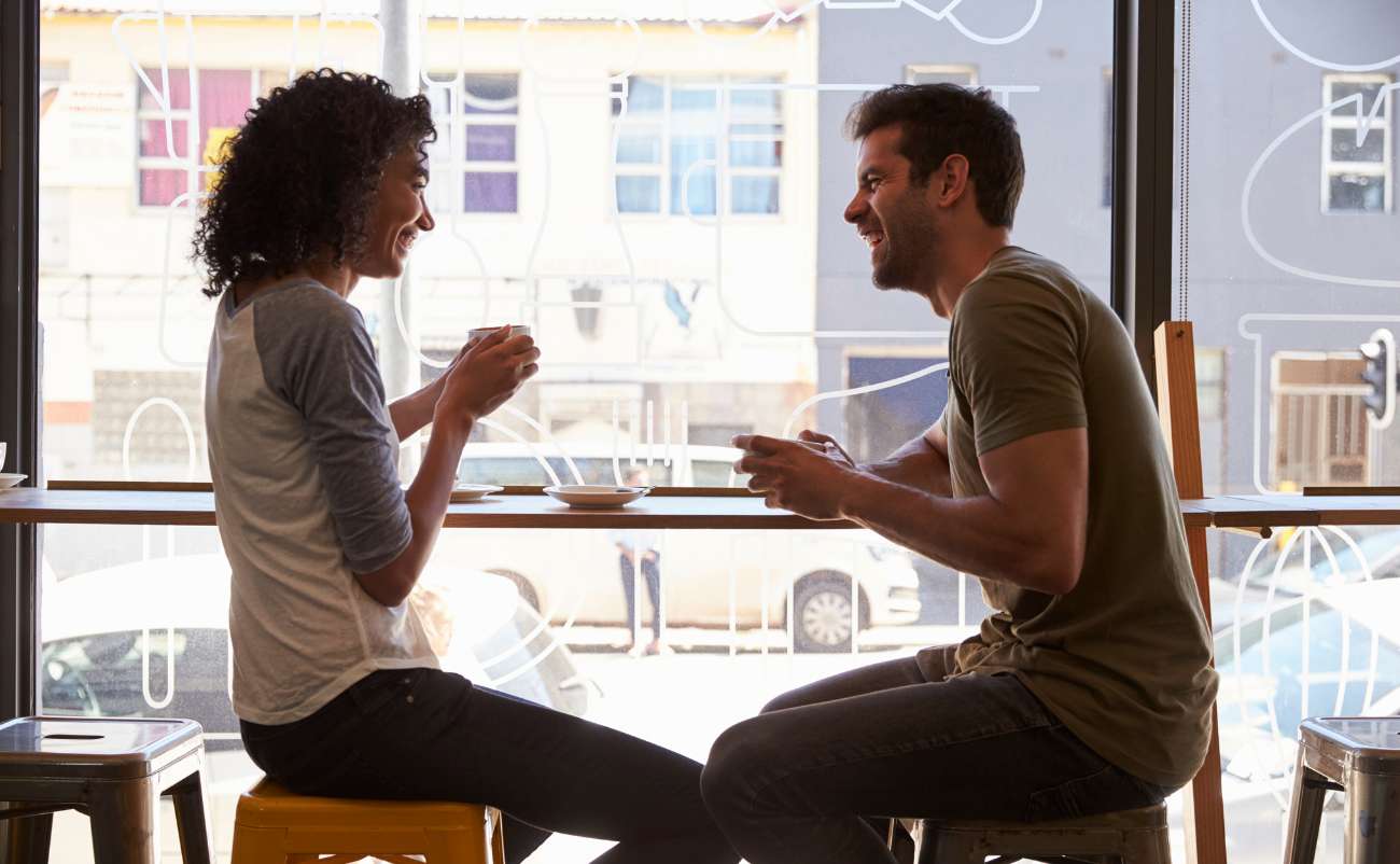 couple talking over coffee to keep relationship positive