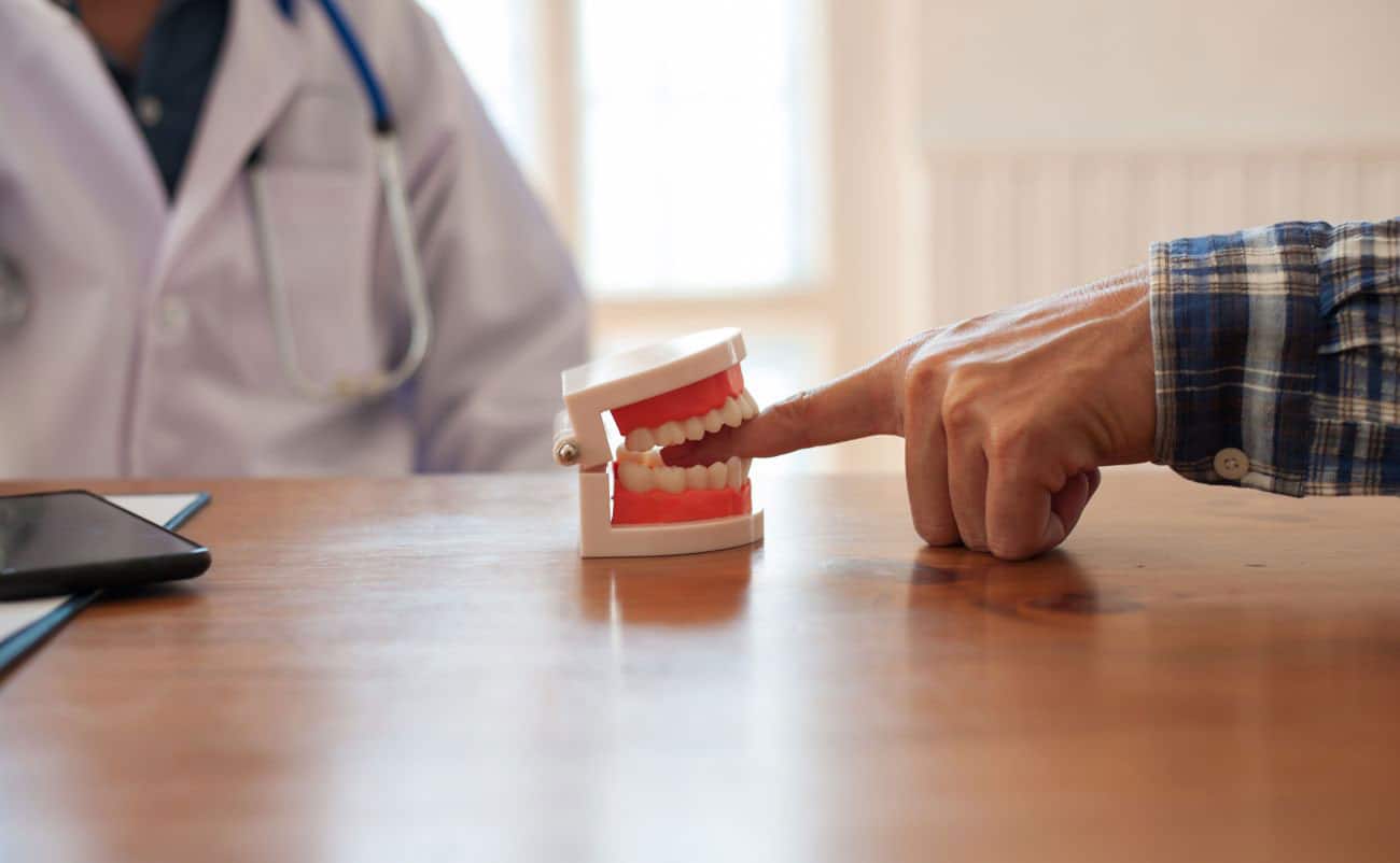 dentist put finger in dental educational jaw for fun