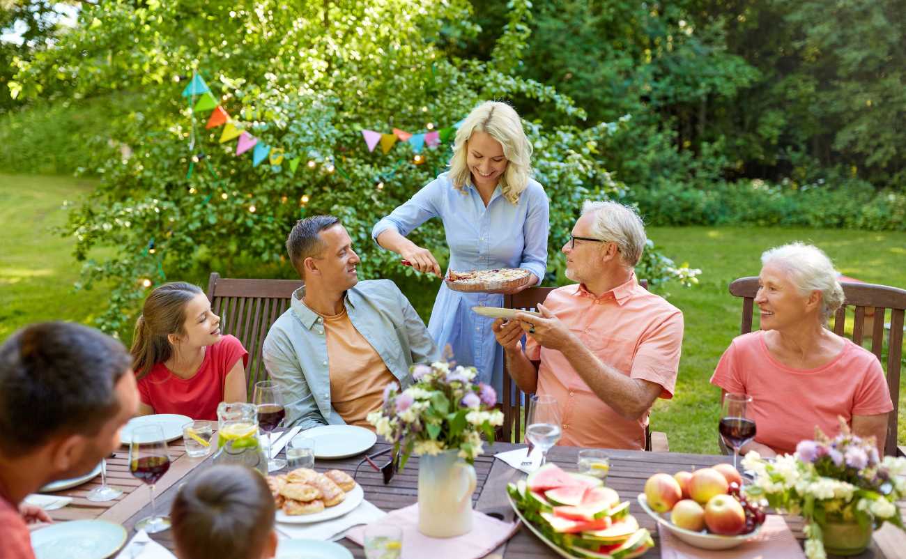 Family discuss on parenting duties while enjoying lunch in the garden together