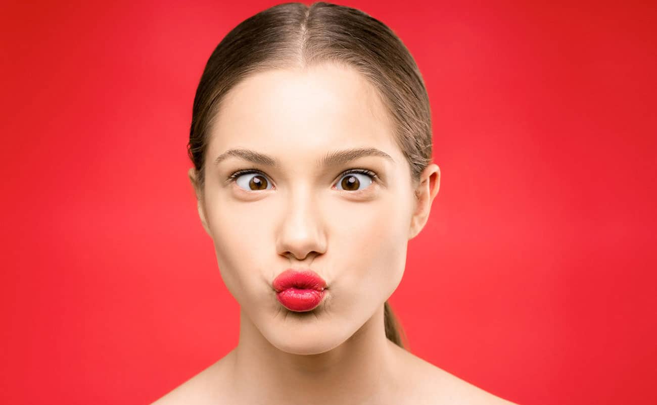 girl making funny face eye in red background