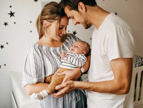 parents holding their baby with care