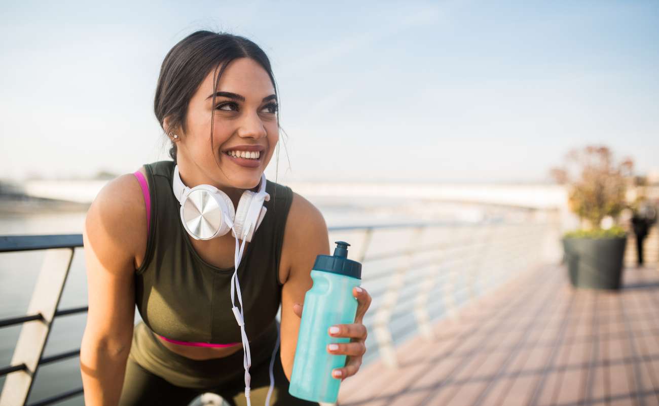 woman sweating out drinking water at park area