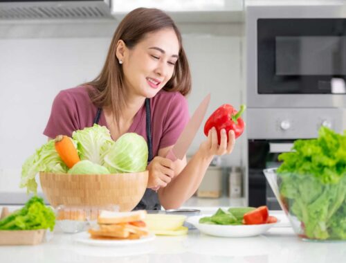 women cutting red pepper and vegetable in the kitchen