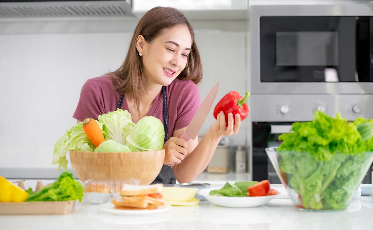 women cutting red pepper and vegetable in the kitchen