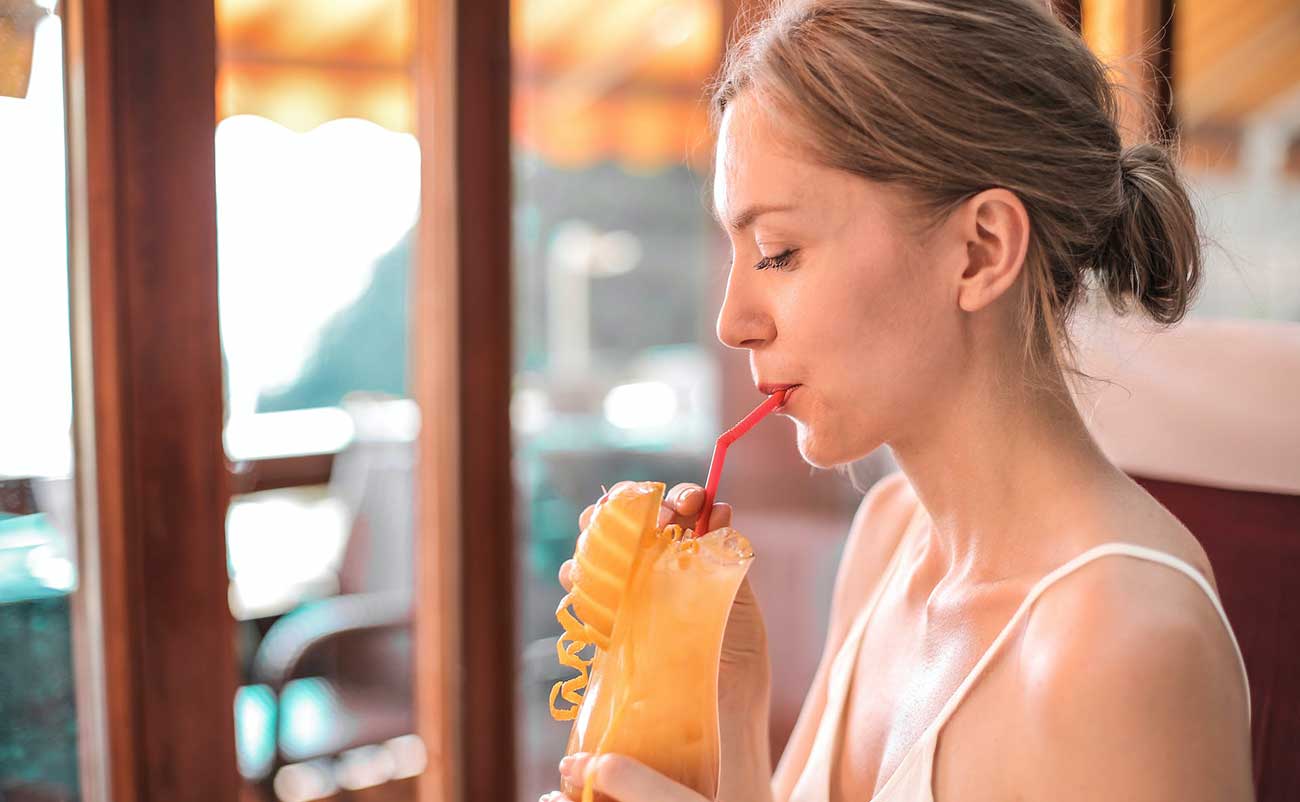 women drinking orange juice at home in summer