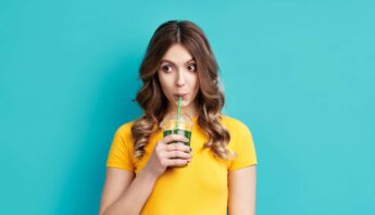 women enjoying drink in the yellow t shirt and blue background