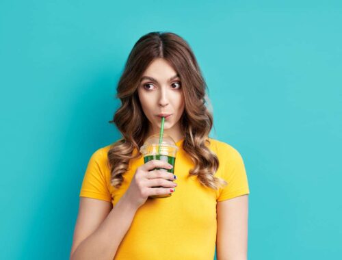 women enjoying drink in the yellow t shirt and blue background