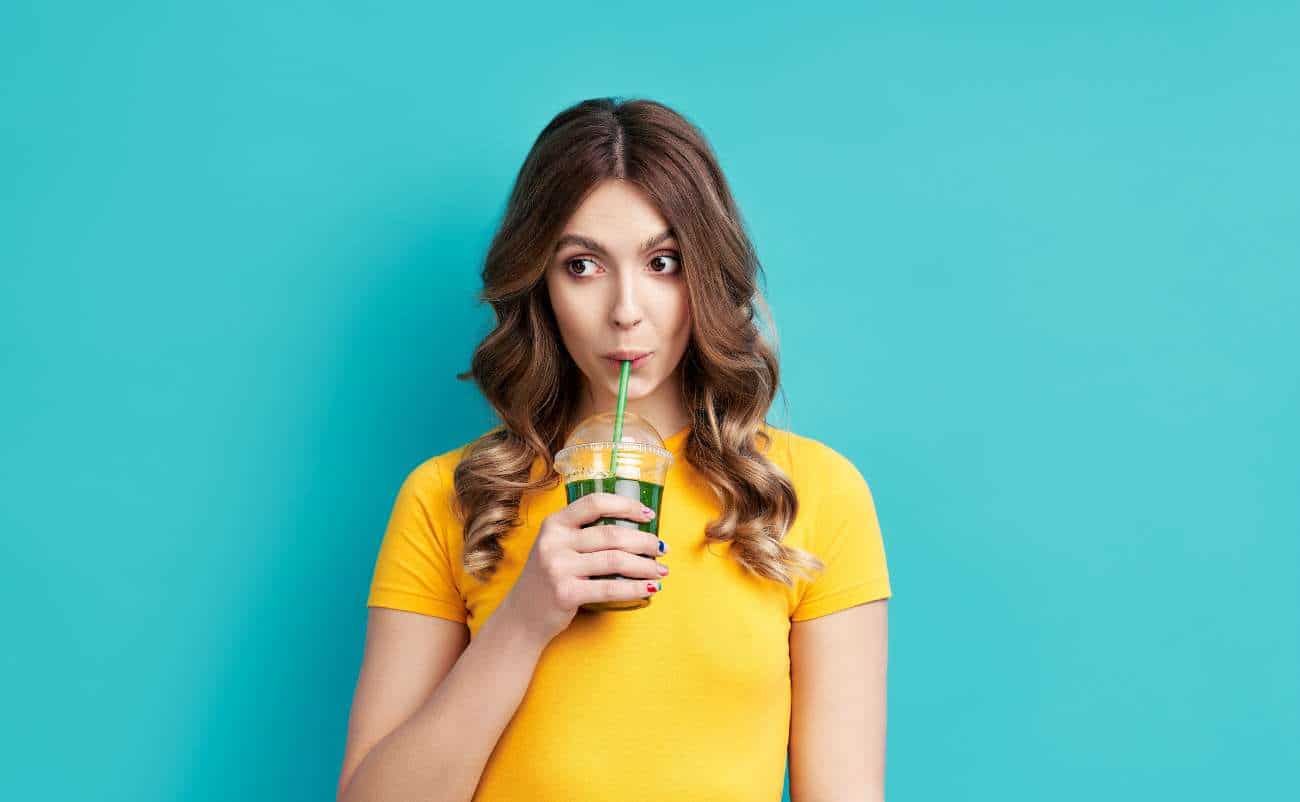 women enjoying drink in the yellow t shirt and blue background