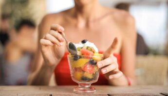 women mixing fruits withicecream in glass