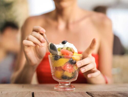 women mixing fruits withicecream in glass