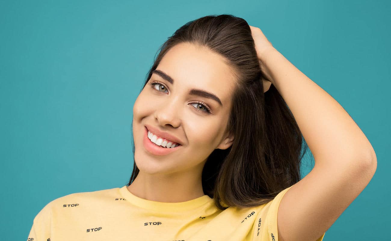 young girl check her hair and makeup and smiling in yellow dress