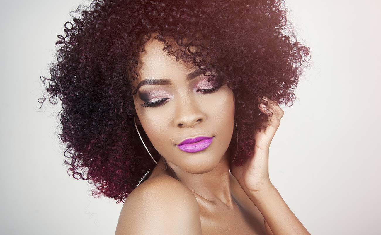 young girl check her self hair and makeup in white background